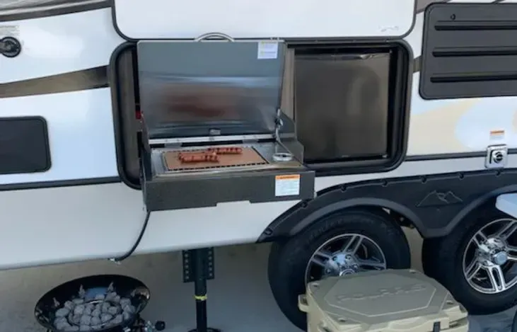 a rv with a grill on the side of it .