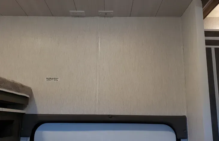 A room with a bed and a shelf on the wall.