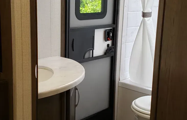 a bathroom with a sink , toilet and shower .