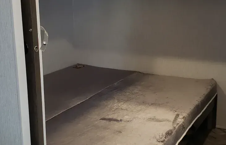 A mattress is sitting in a closet next to a door.