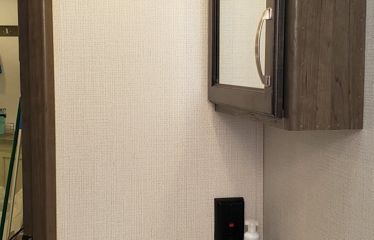 a bathroom with a sink , mirror and cabinet .