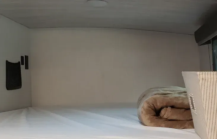 a bed with a blanket on it in a camper van .