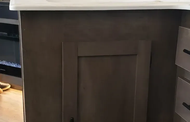 A bathroom vanity with a sink and a fireplace in the background.