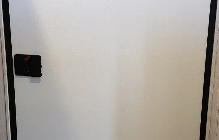 A white door with a black handle in a room.