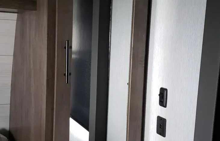 A room with a door and a mirror on the wall.