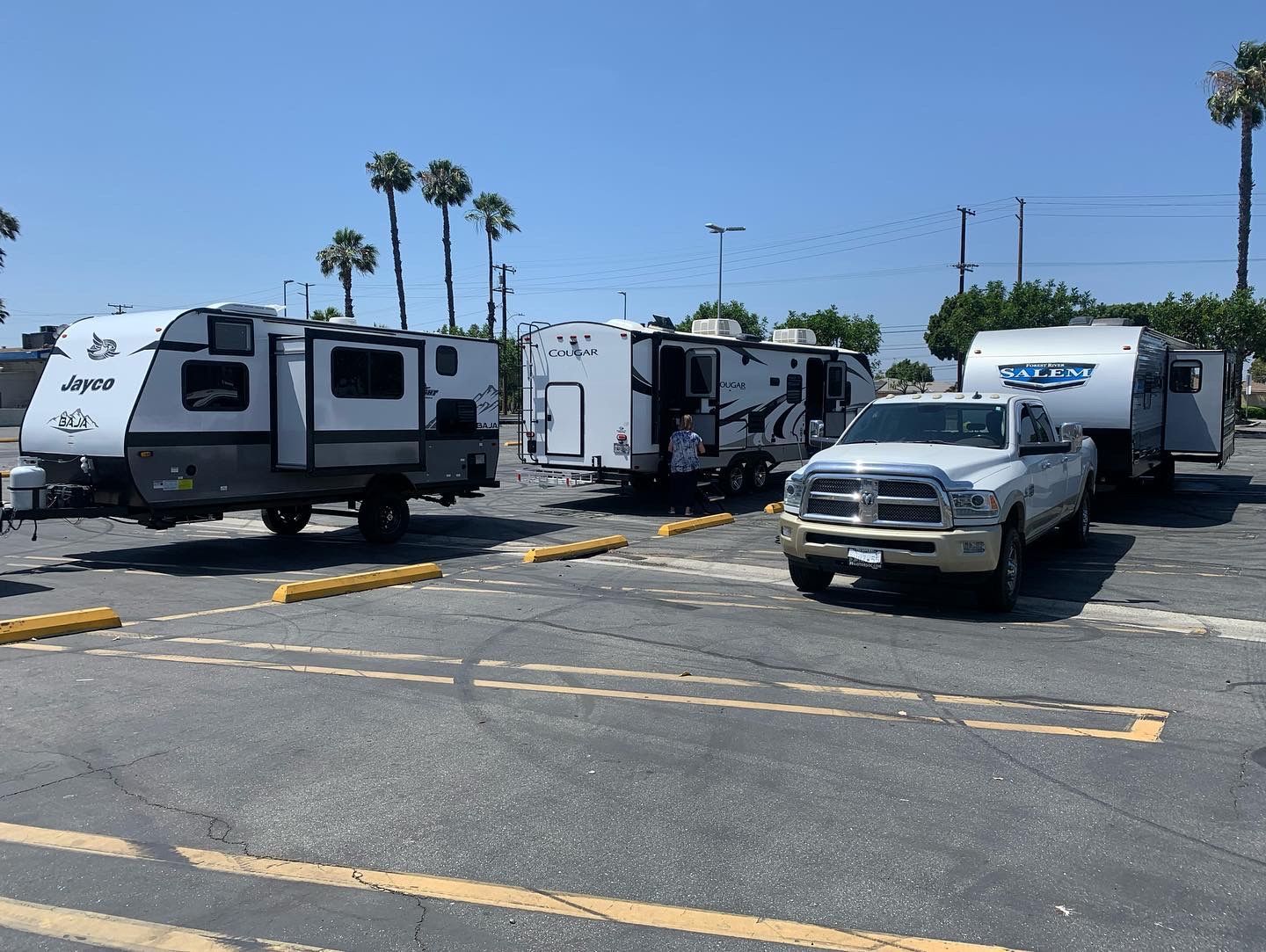 a row of rvs are parked in a parking lot .