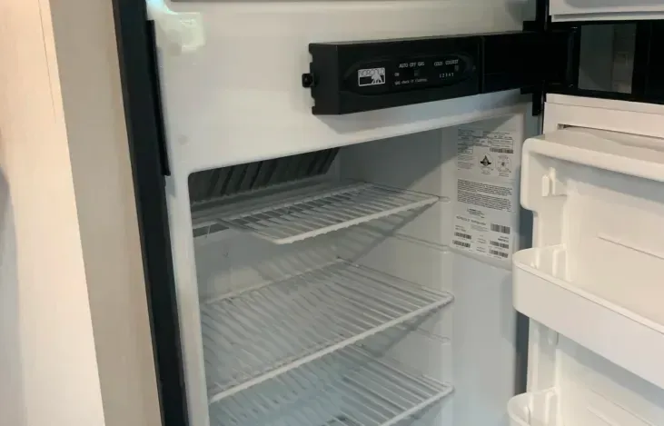 The inside of an empty refrigerator with the door open.
