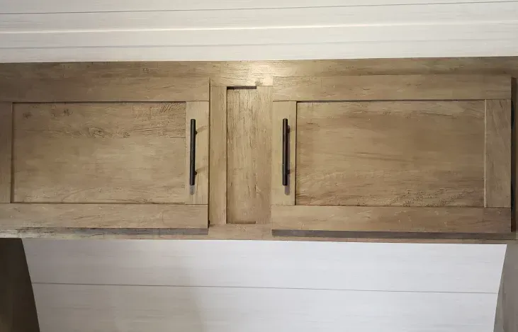 The cabinets are made of wood and have black handles.