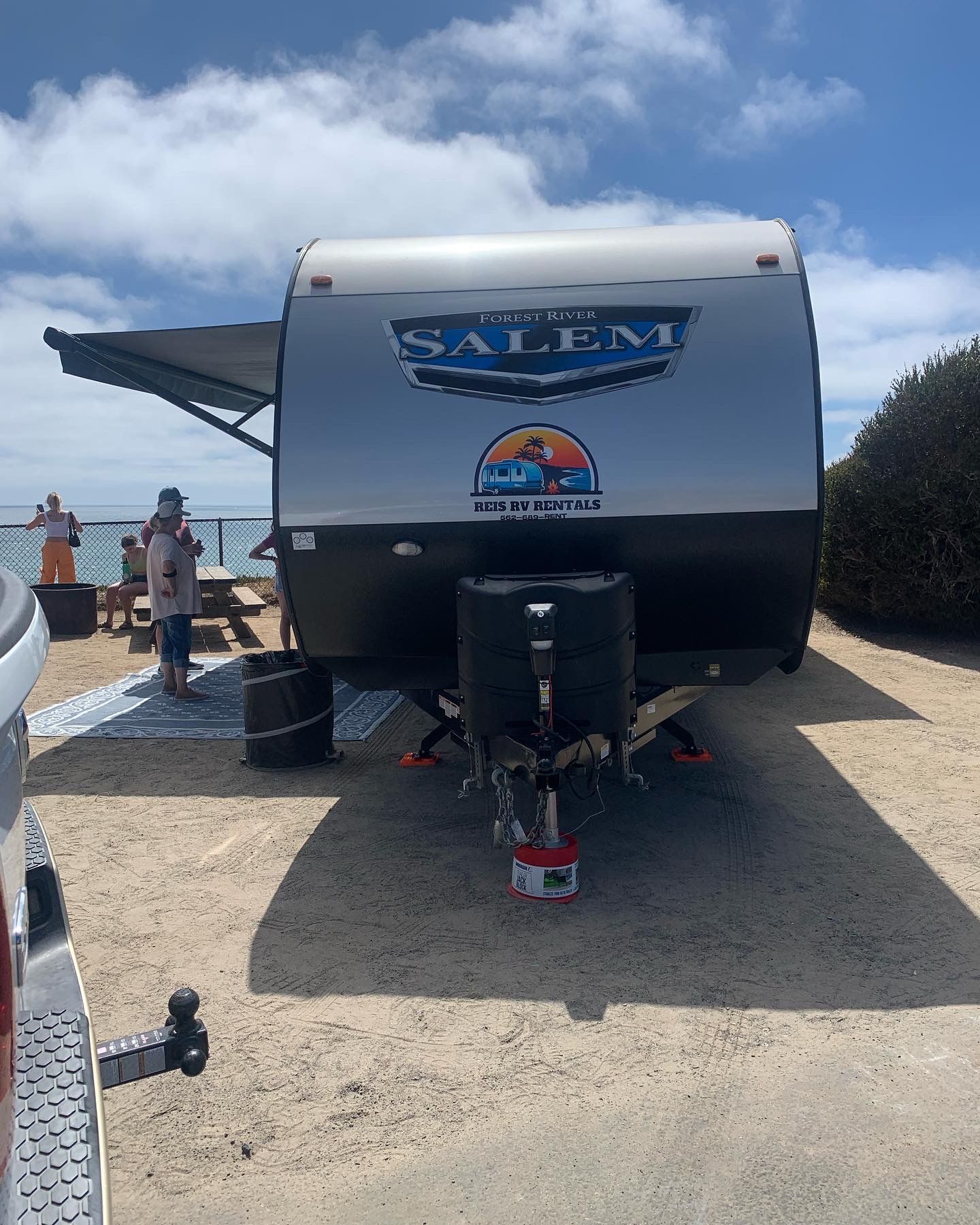 a trailer is parked in a parking lot next to a beach .