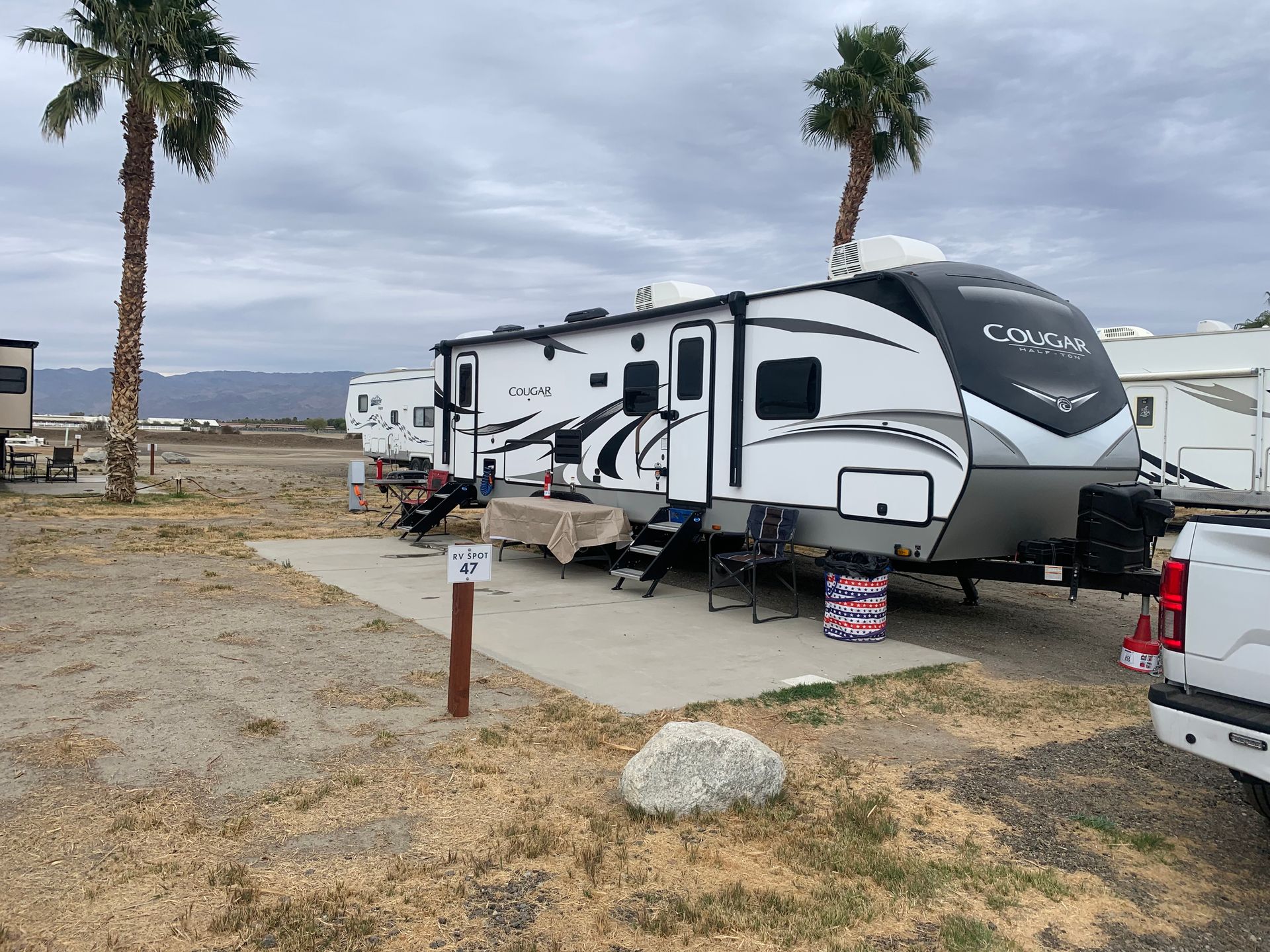 a rv is parked in a lot next to a truck .