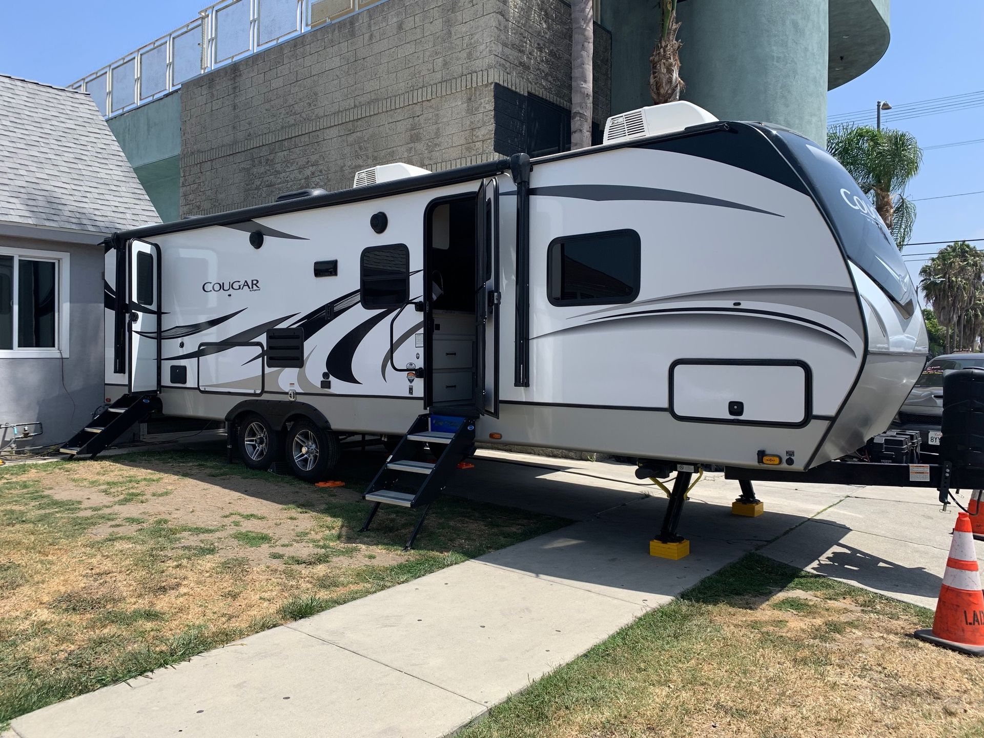 a white rv is parked in front of a house .
