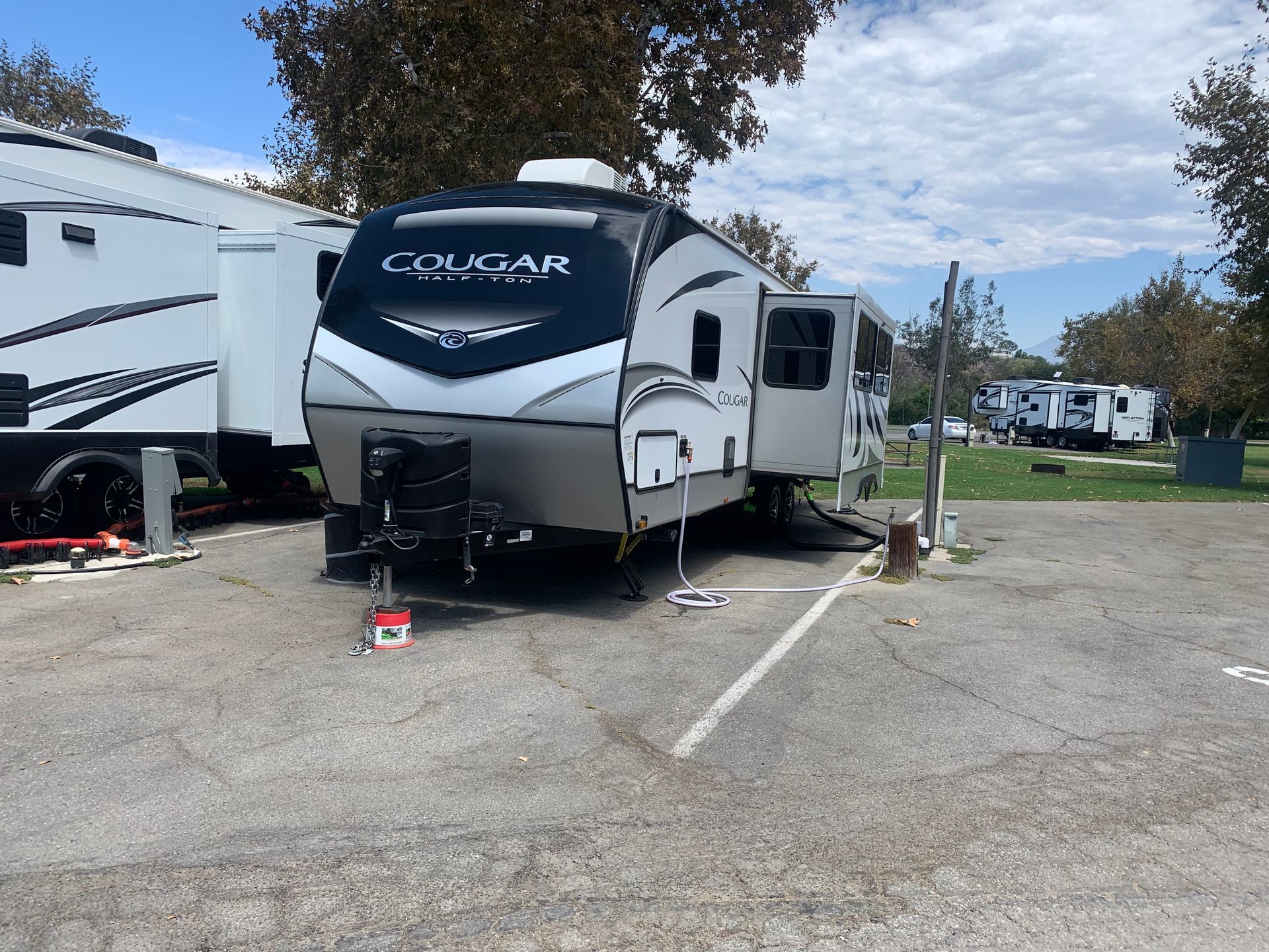 a white rv is parked in a parking lot .
