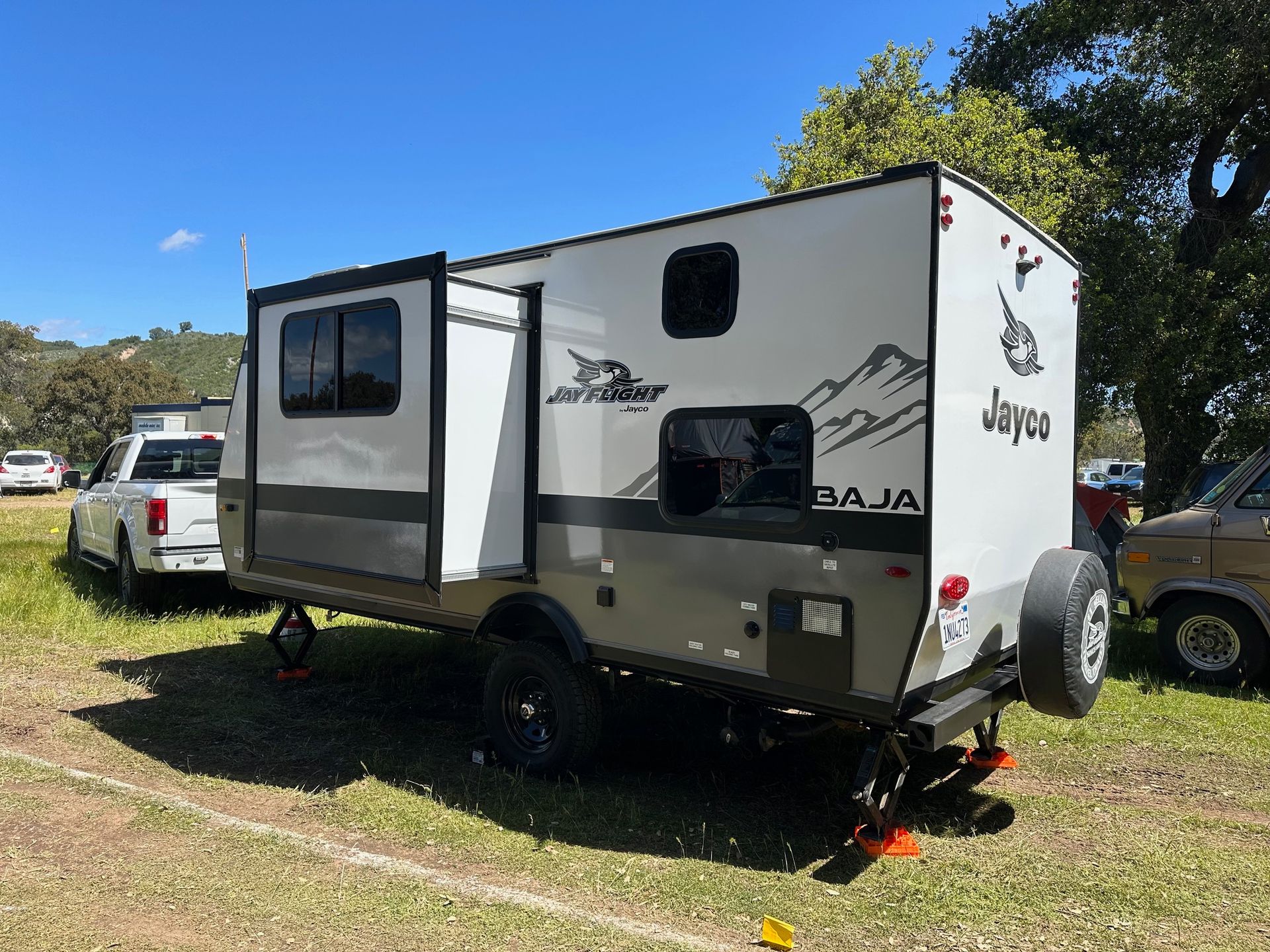 a trailer is parked in a grassy field next to a truck .