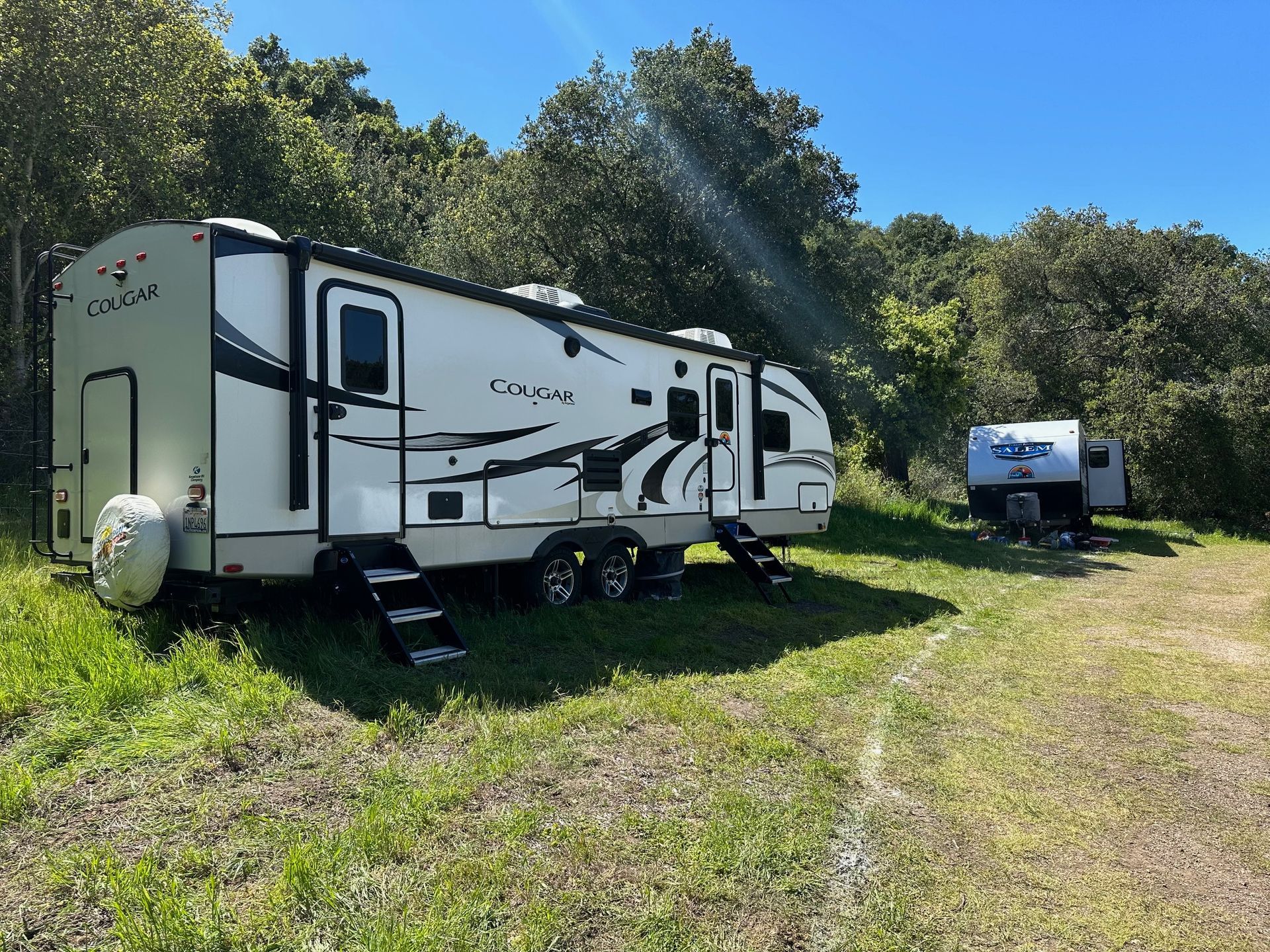 a couple of trailers are parked in a grassy field .