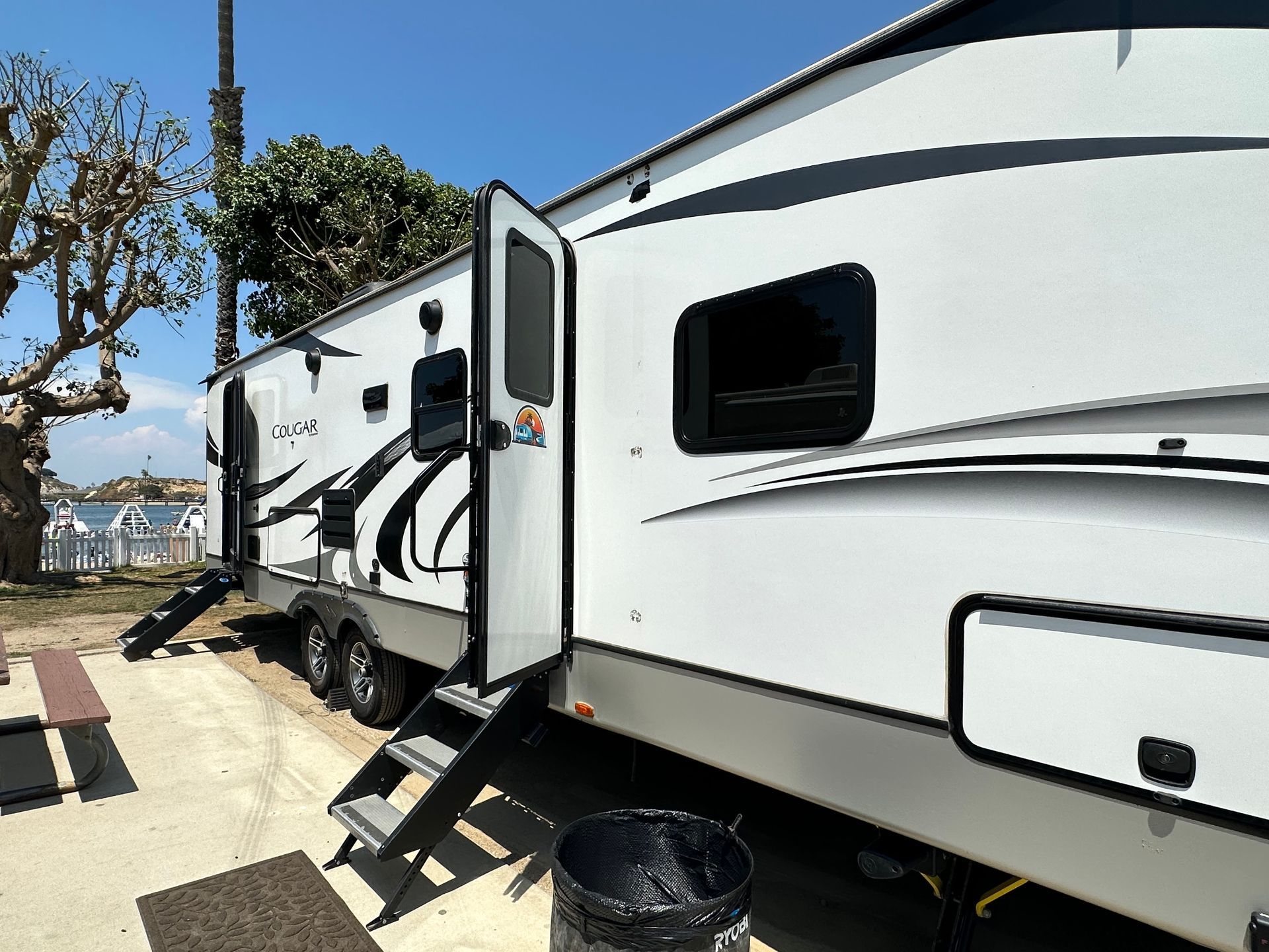 two white rvs are parked next to each other in a parking lot .
