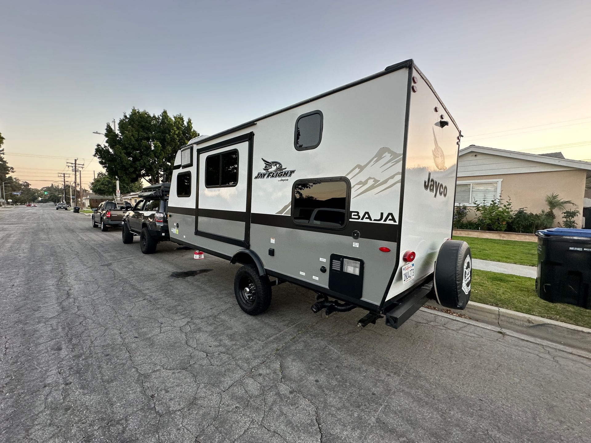 a trailer is parked on the side of the road next to a house .