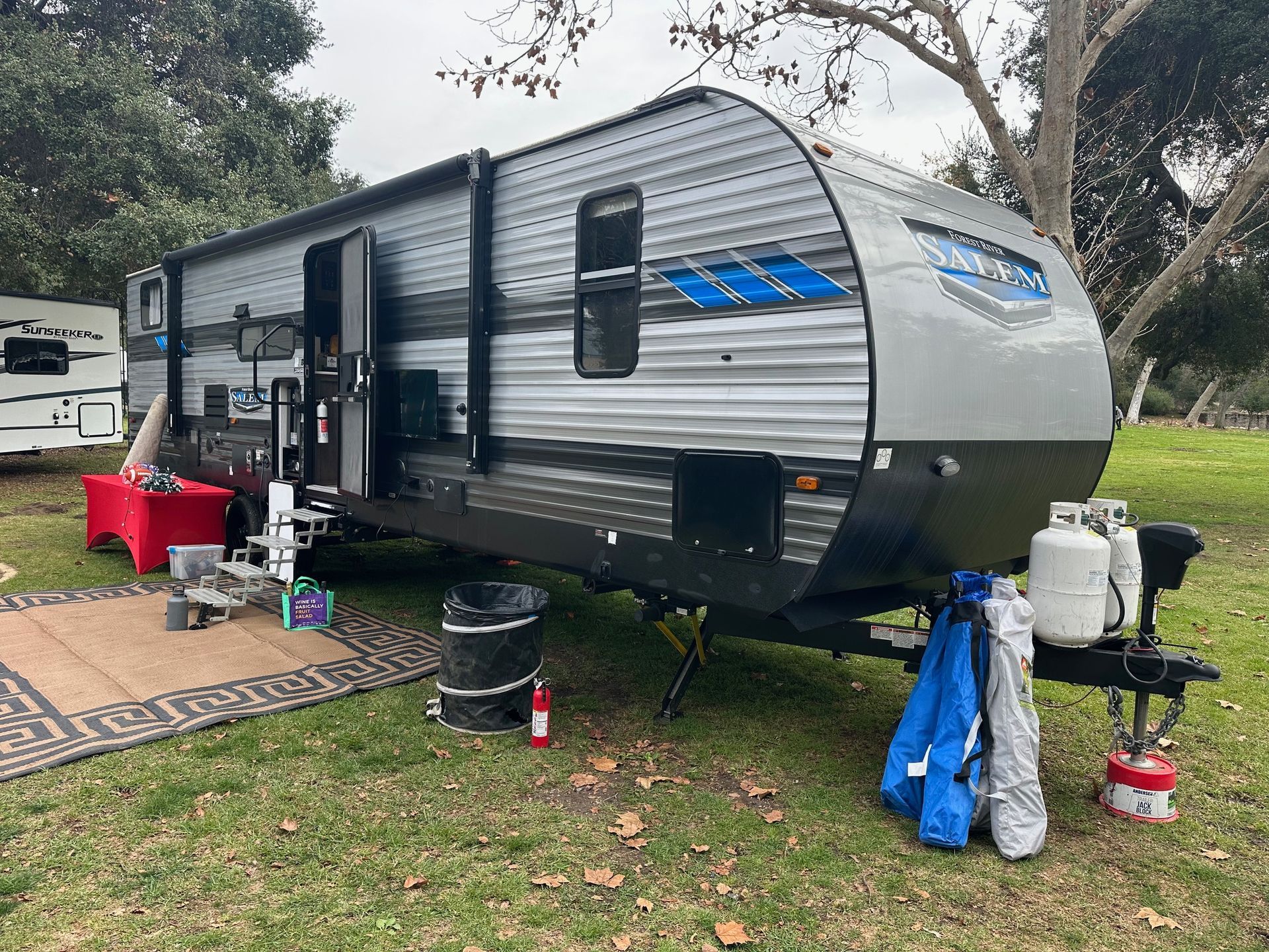 a camper trailer is parked in a grassy field .