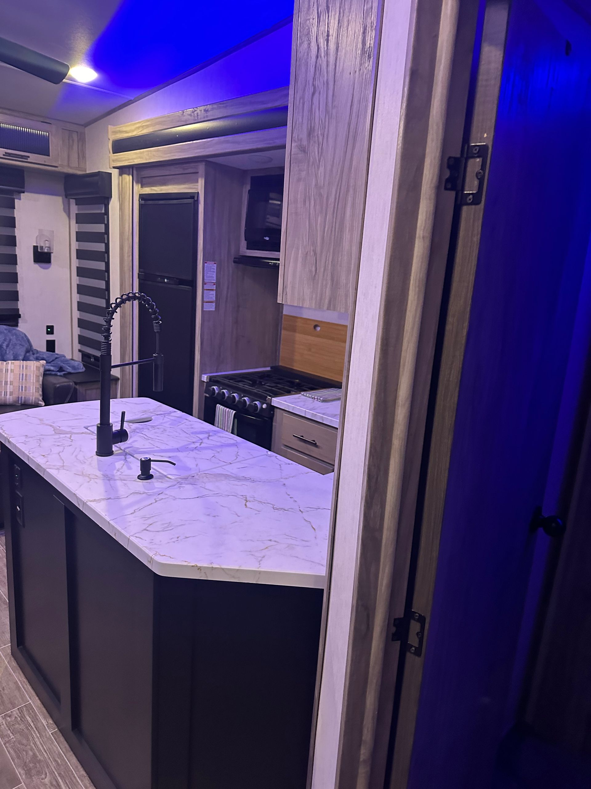 A kitchen in a rv with a large island in the middle of the room.