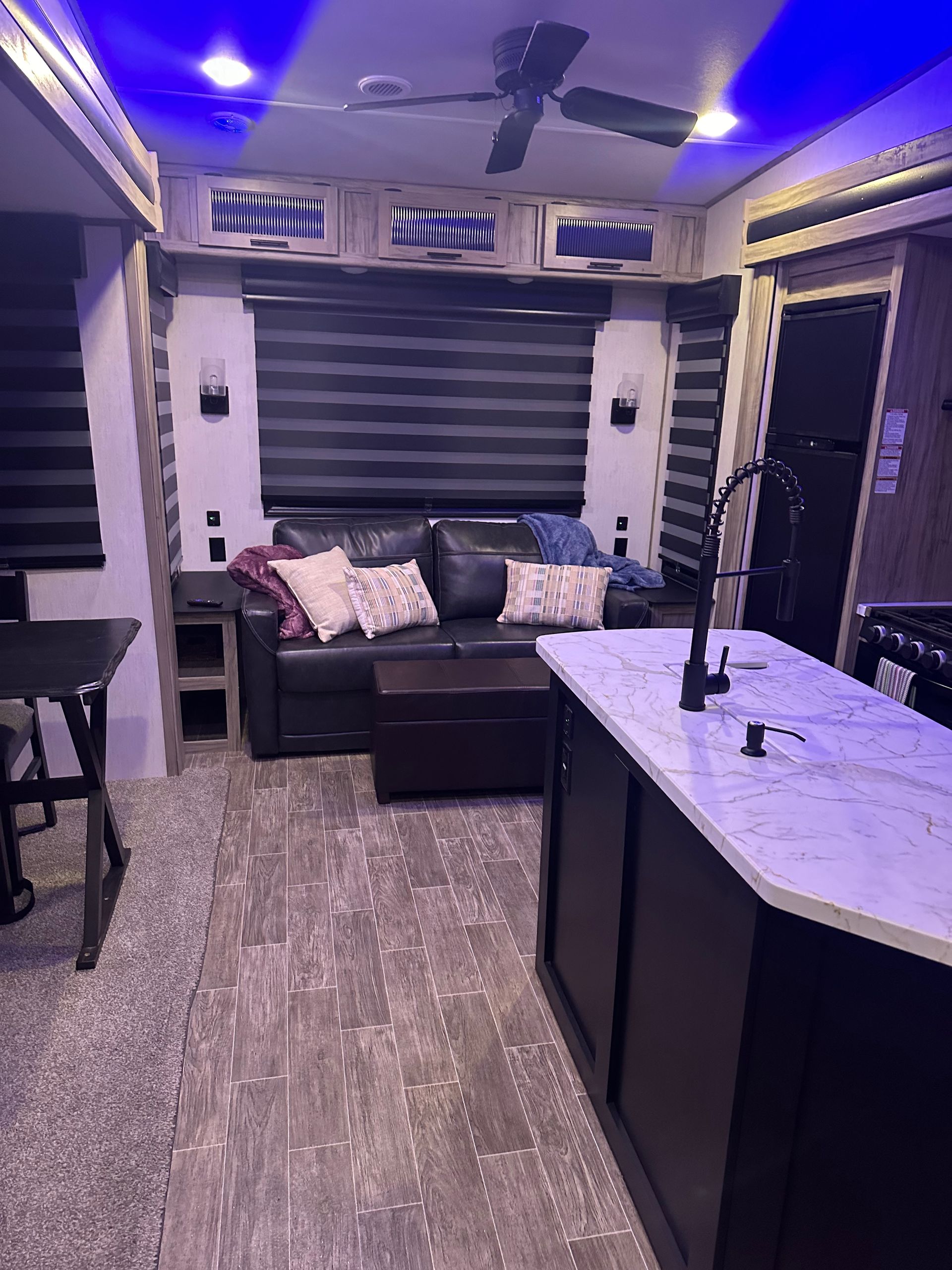 A living room with a couch and a kitchen in a rv.