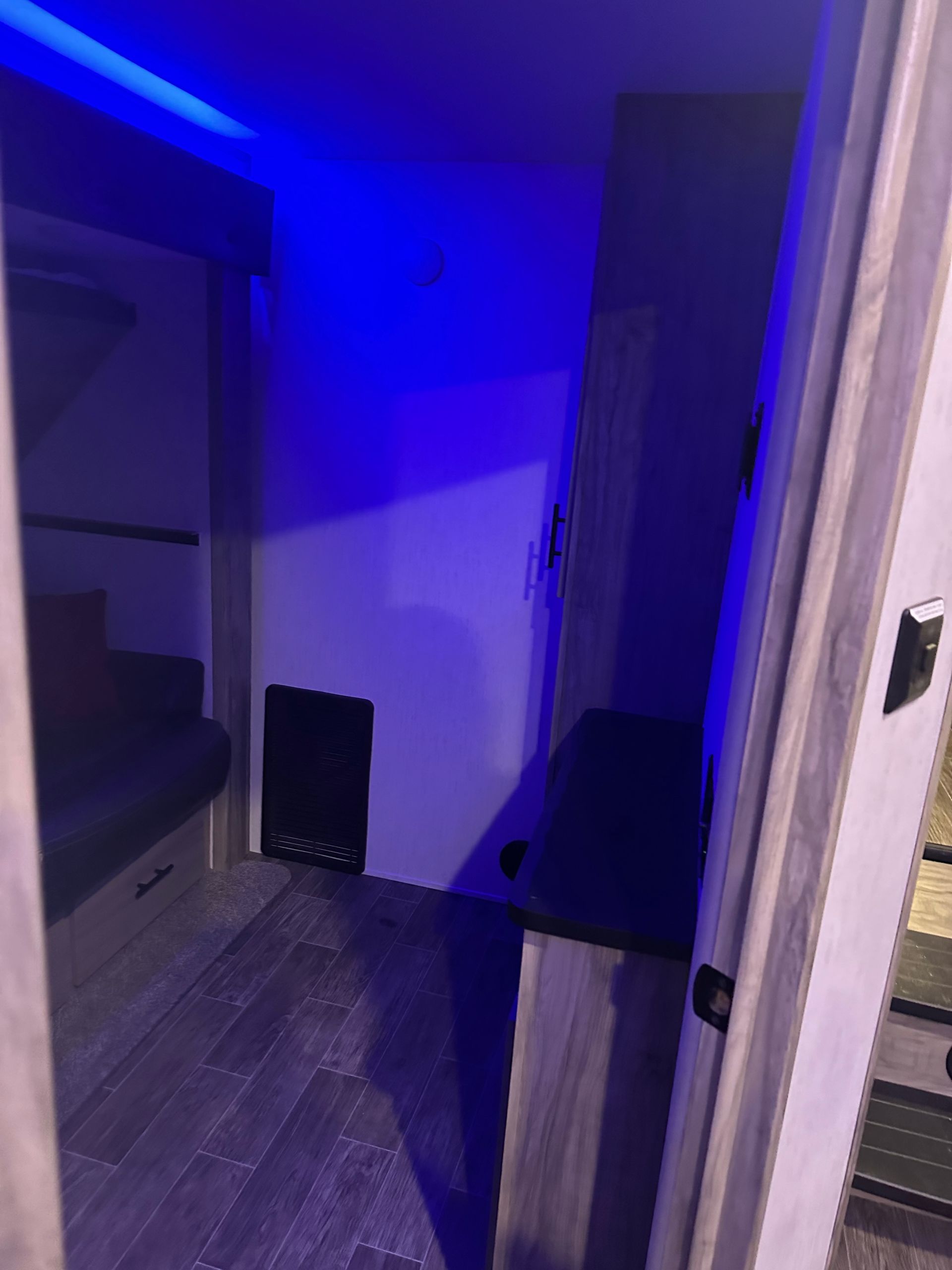 A room with blue lights on the ceiling and a couch.