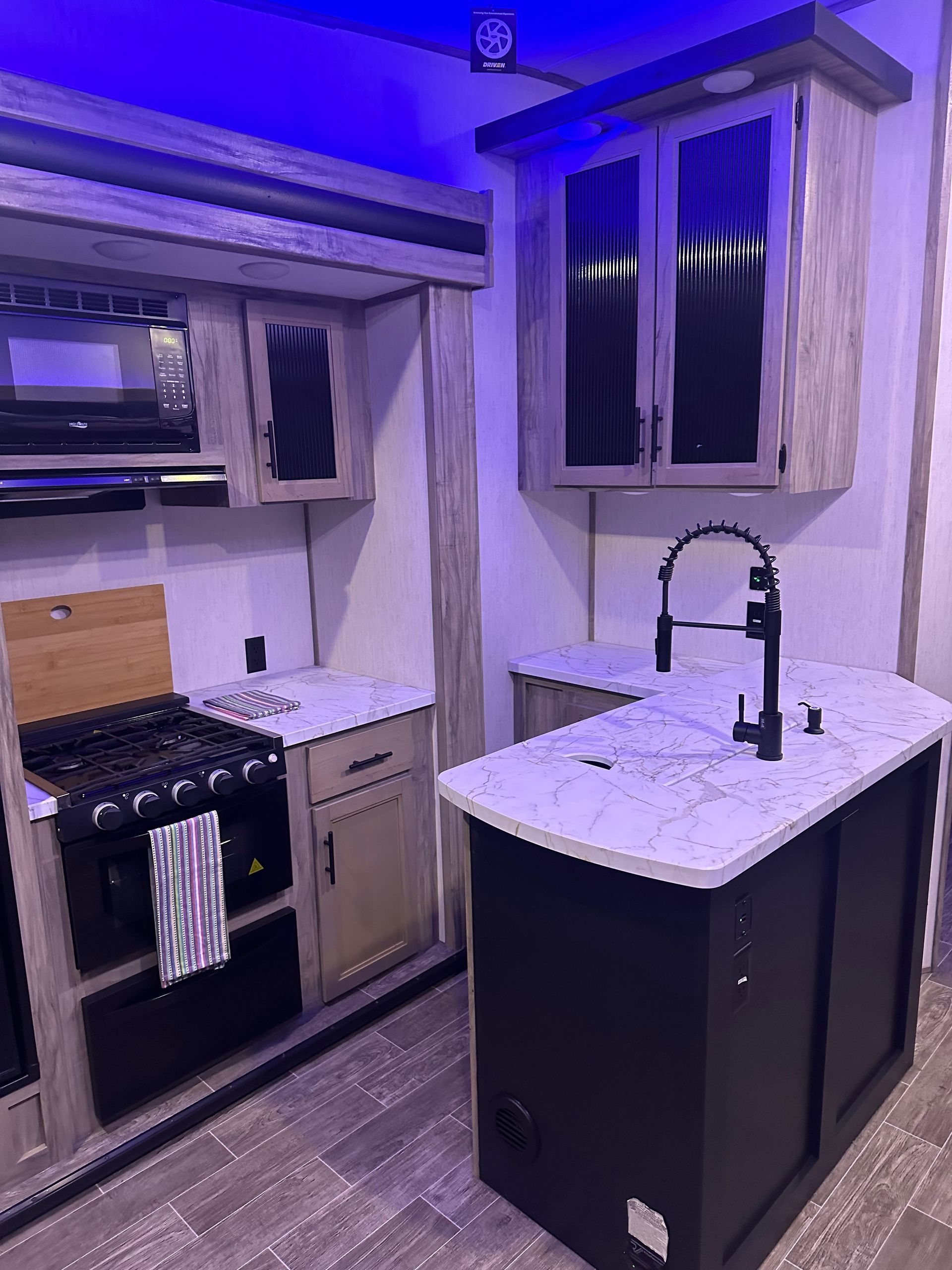 A kitchen with a stove , sink , and cabinets.