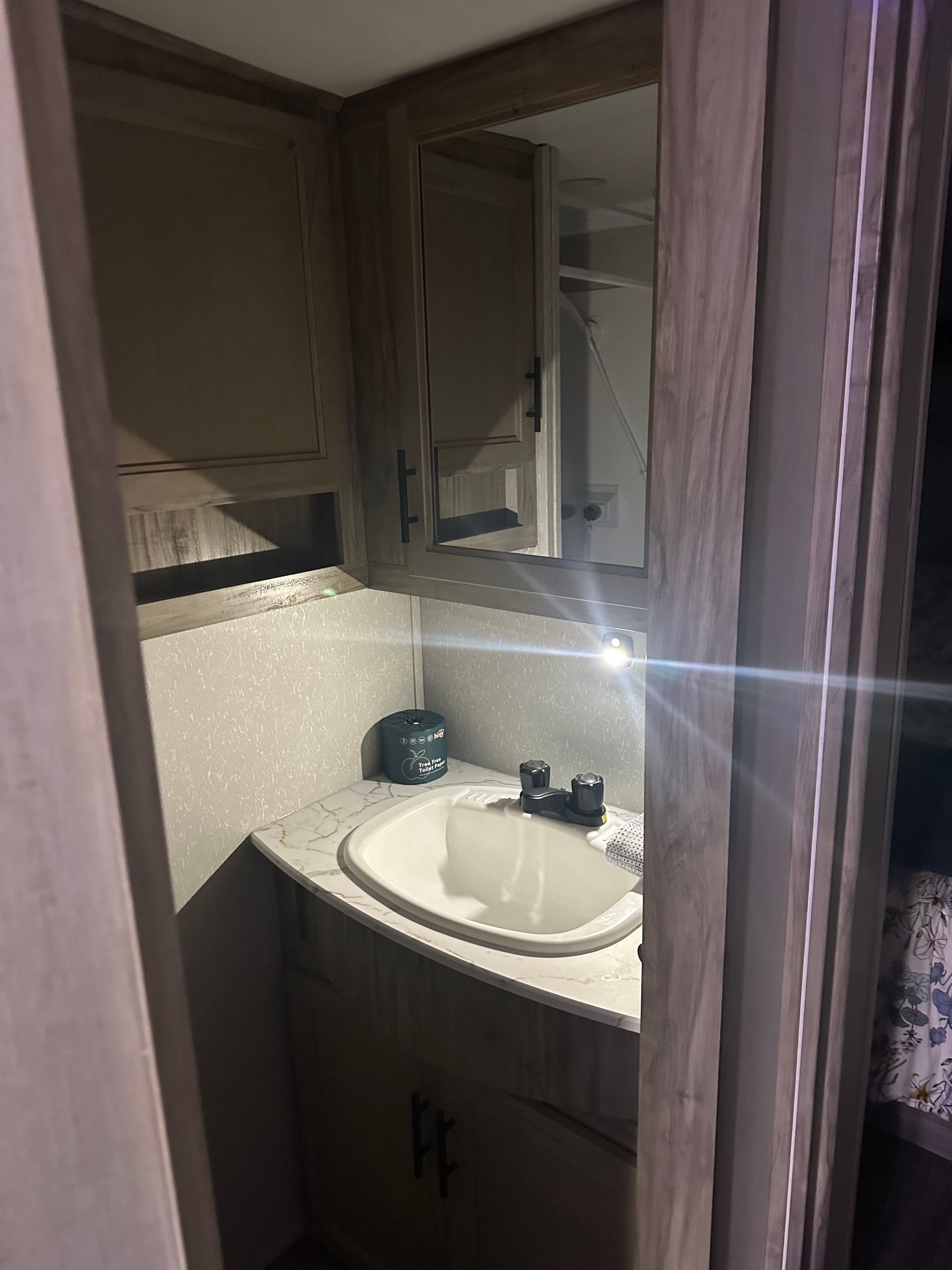 A bathroom with a sink , mirror and cabinets.