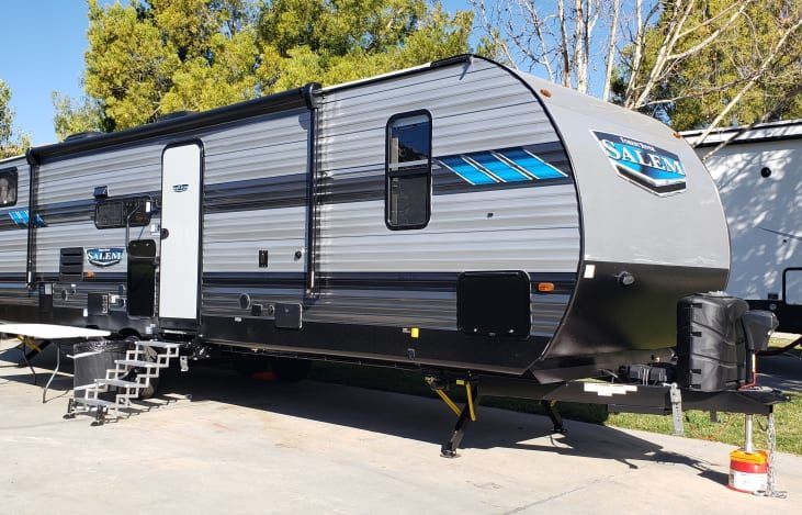 A black and white trailer is parked in a parking lot.
