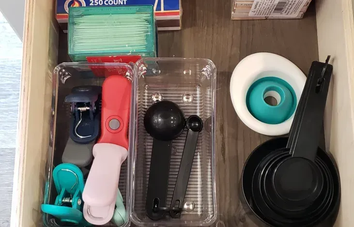 a drawer filled with a variety of kitchen utensils and matches .