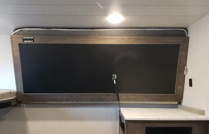 A chalkboard is hanging above a counter in a kitchen.