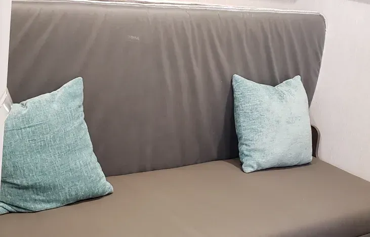 A couch with two pillows on it in a room.