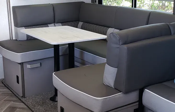 A rv with a couch and a table in it.