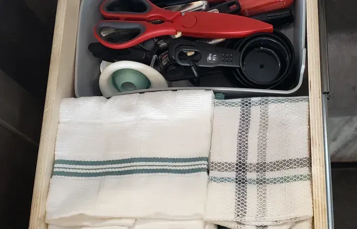 A drawer with a towel and scissors in it