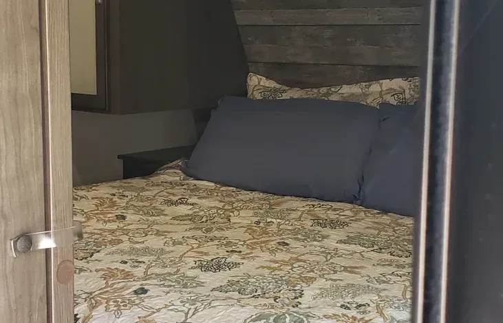 a bedroom with a bed , nightstand , and mirror .