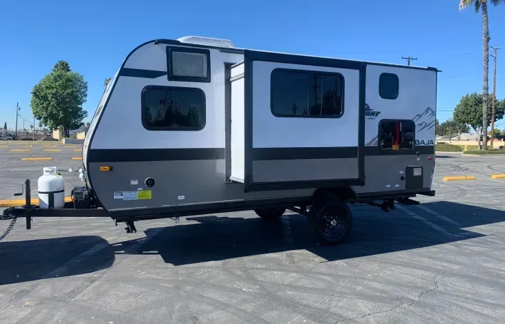 A small trailer is parked in a parking lot.