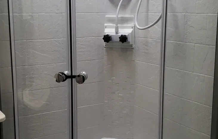 A bathroom with a shower stall and a shower head.