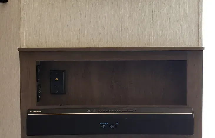 A tv mounted on a wall next to a sound bar.
