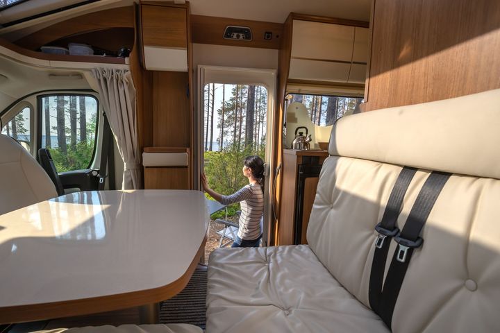 a woman in the door of the camper looking outside. a woman in the door of the camper looking outside.