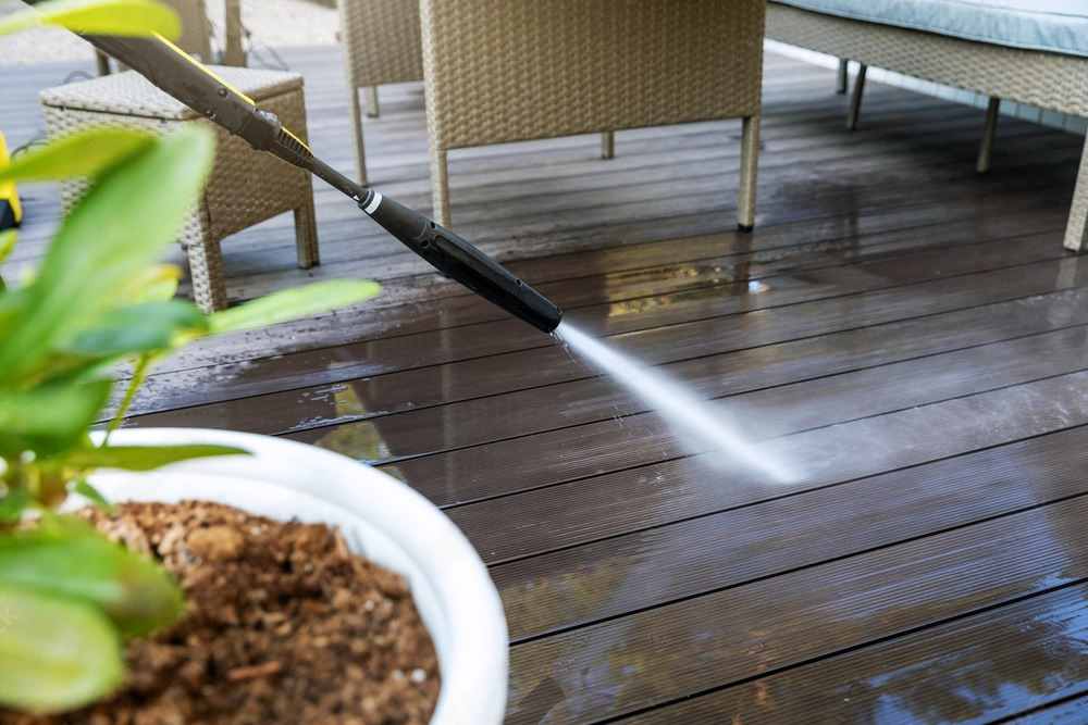 a high pressure washer is spraying water on a wooden deck