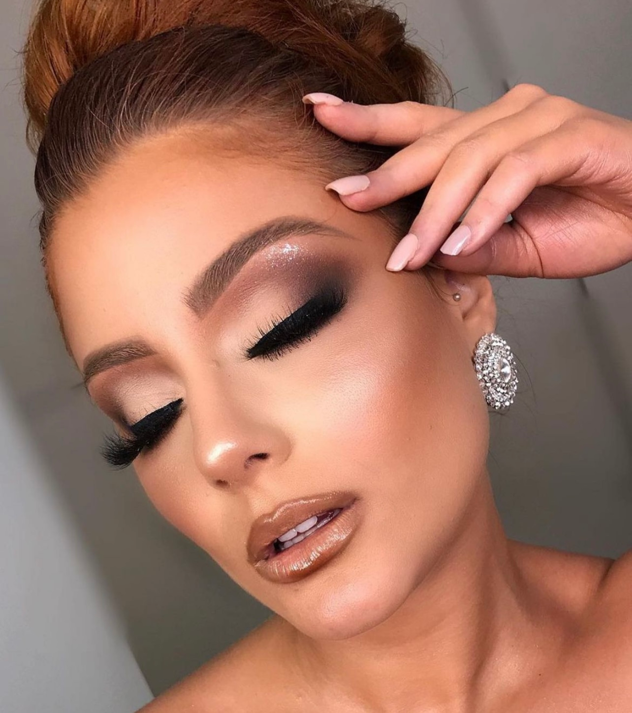 A close up of a woman 's face with makeup and earrings