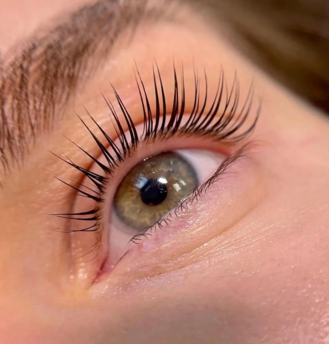 A close up of a woman 's eye with long eyelashes