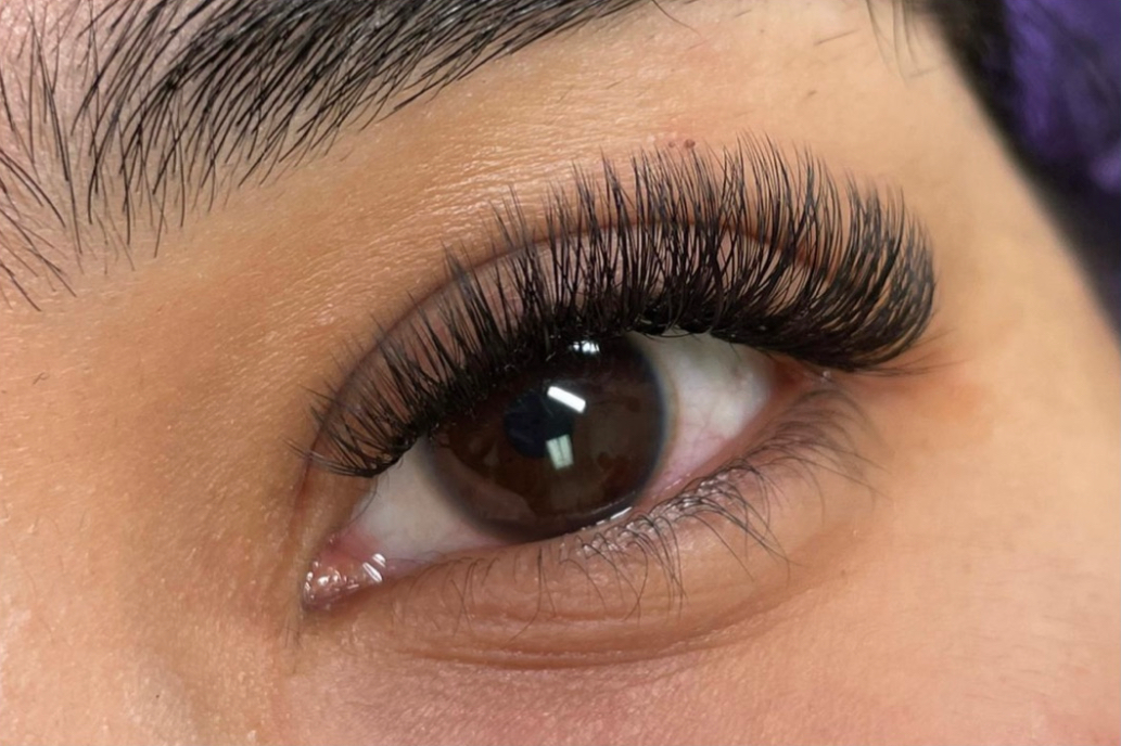 A close up of a woman 's eye with long eyelashes.