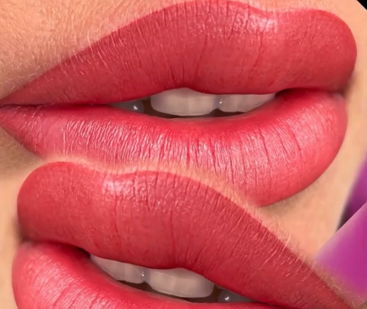A close up of a woman 's lips with red lipstick and white teeth.