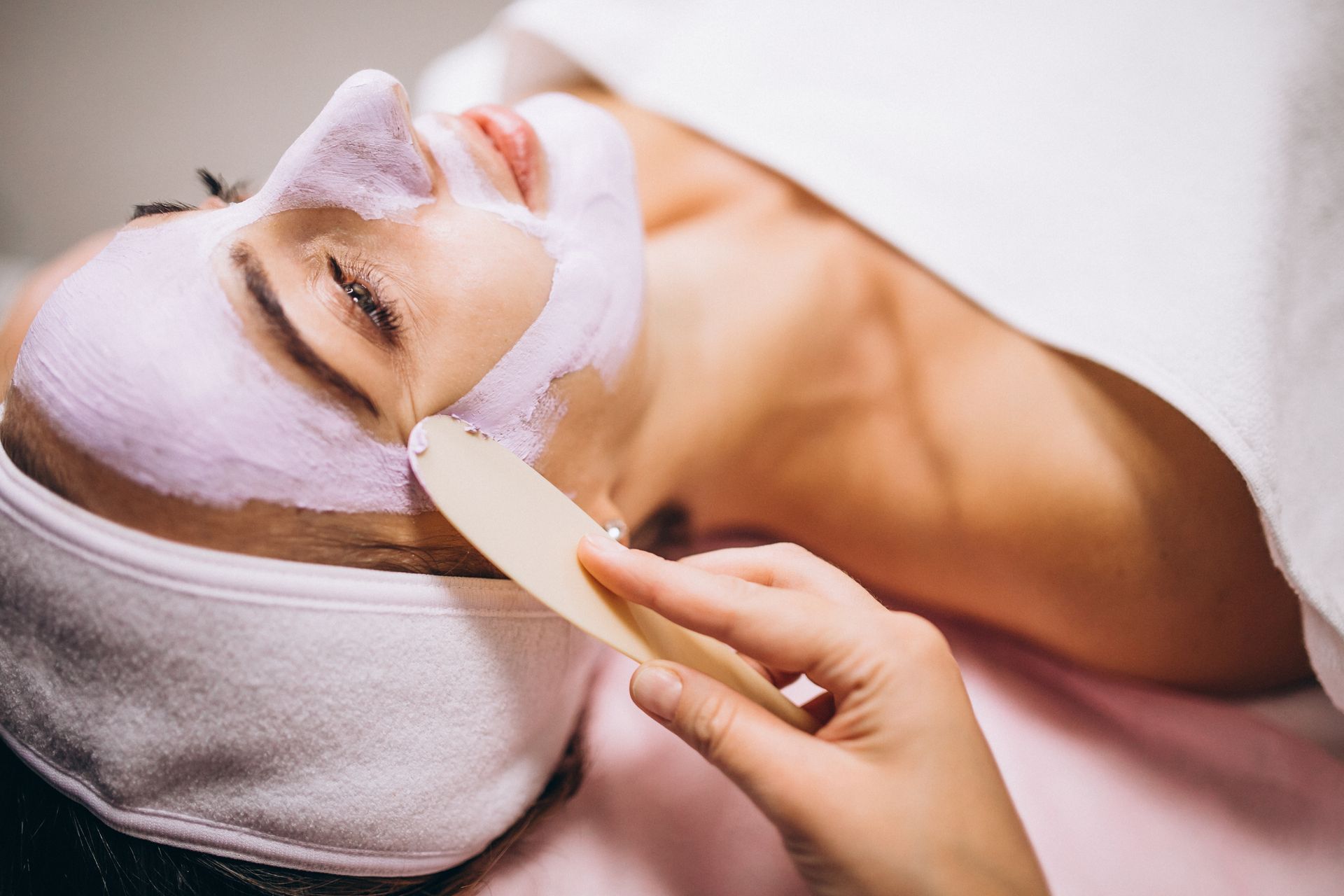 A woman is getting a facial treatment at a spa.