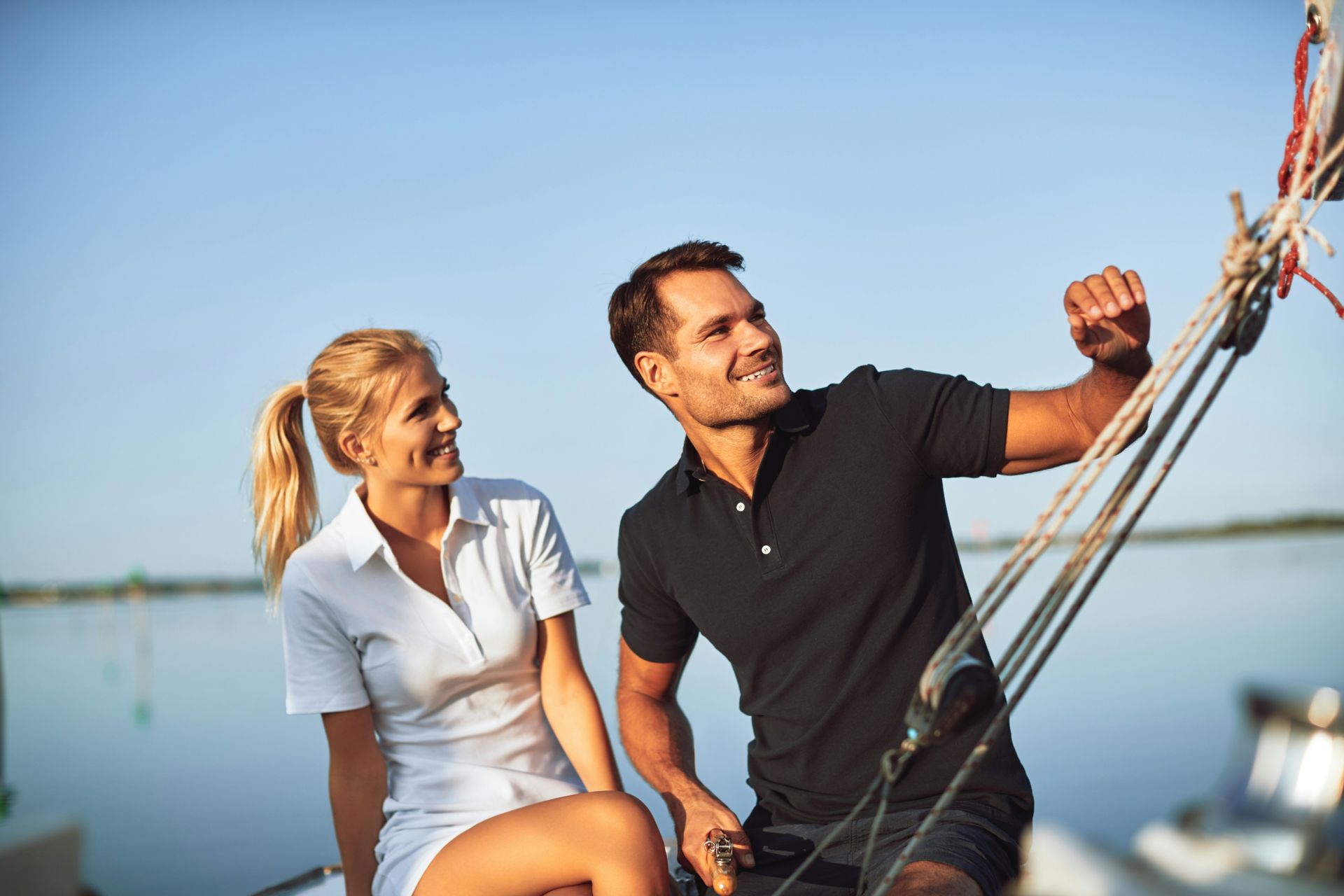 A man and a woman are sitting on a boat in the water.