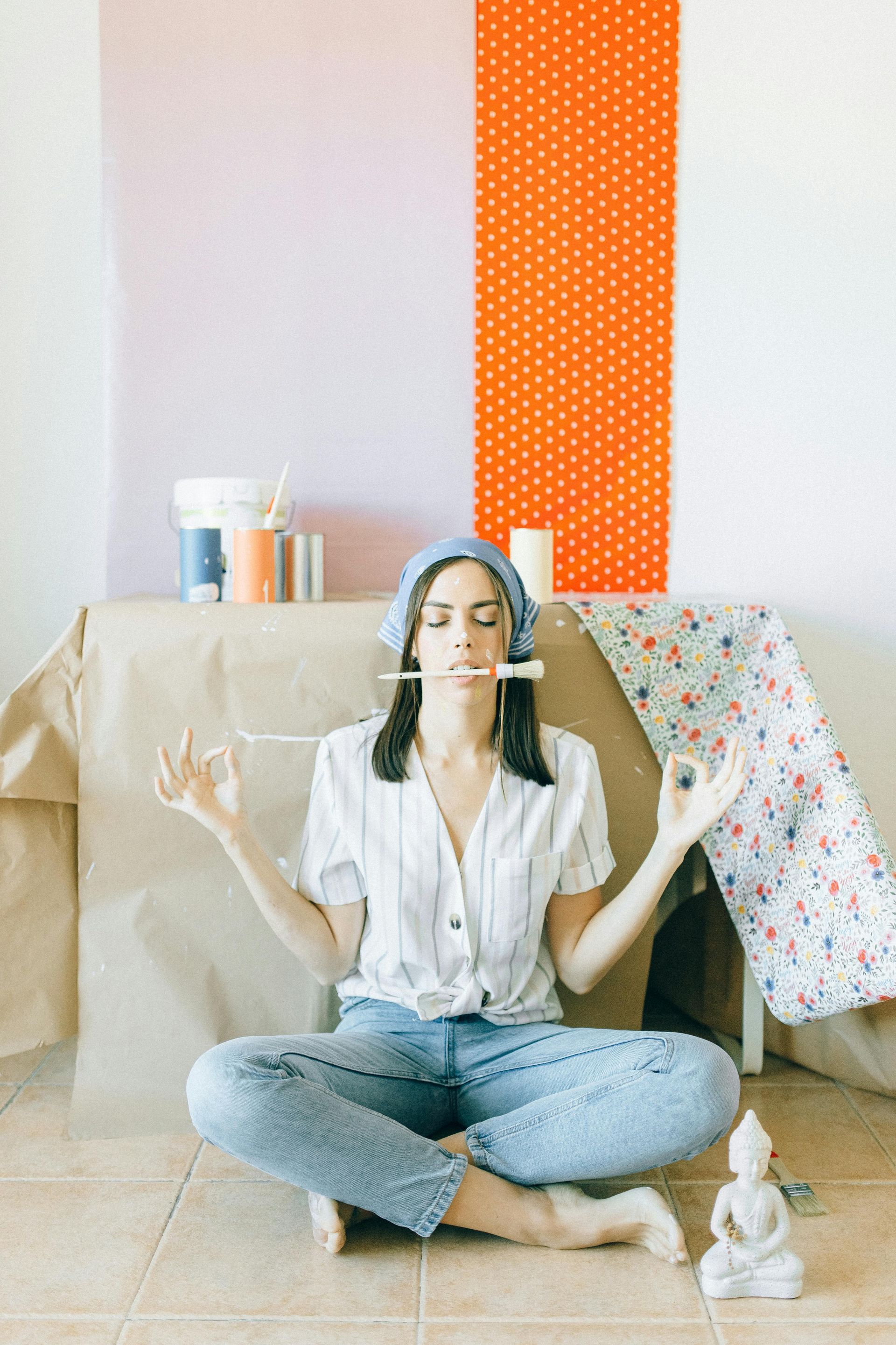 lady in meditation pose holding a paint brush