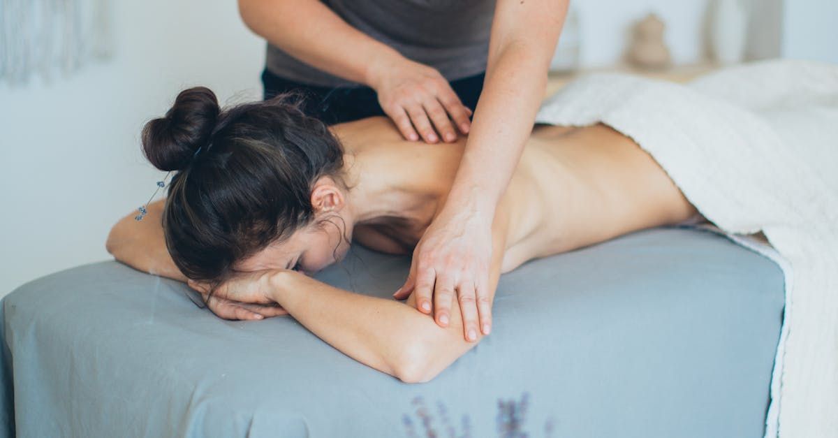 a woman face down receiving a massage from a man