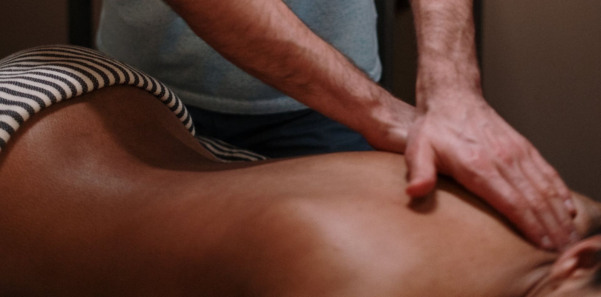 A man is giving a woman a massage on her back.