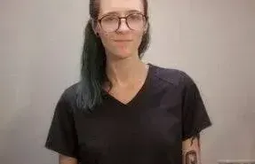 a massage therapist looking into the camera and smiling