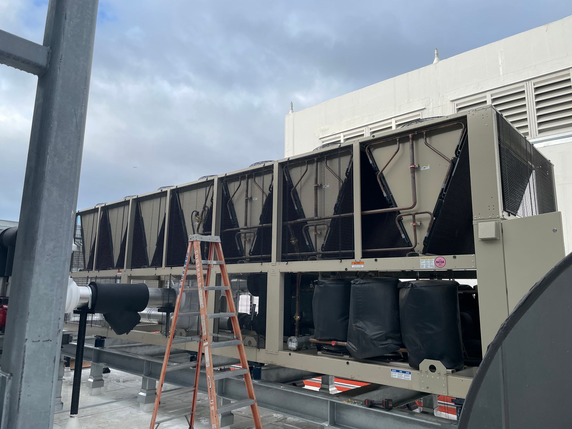 A large air conditioner is being installed on the roof of a building.