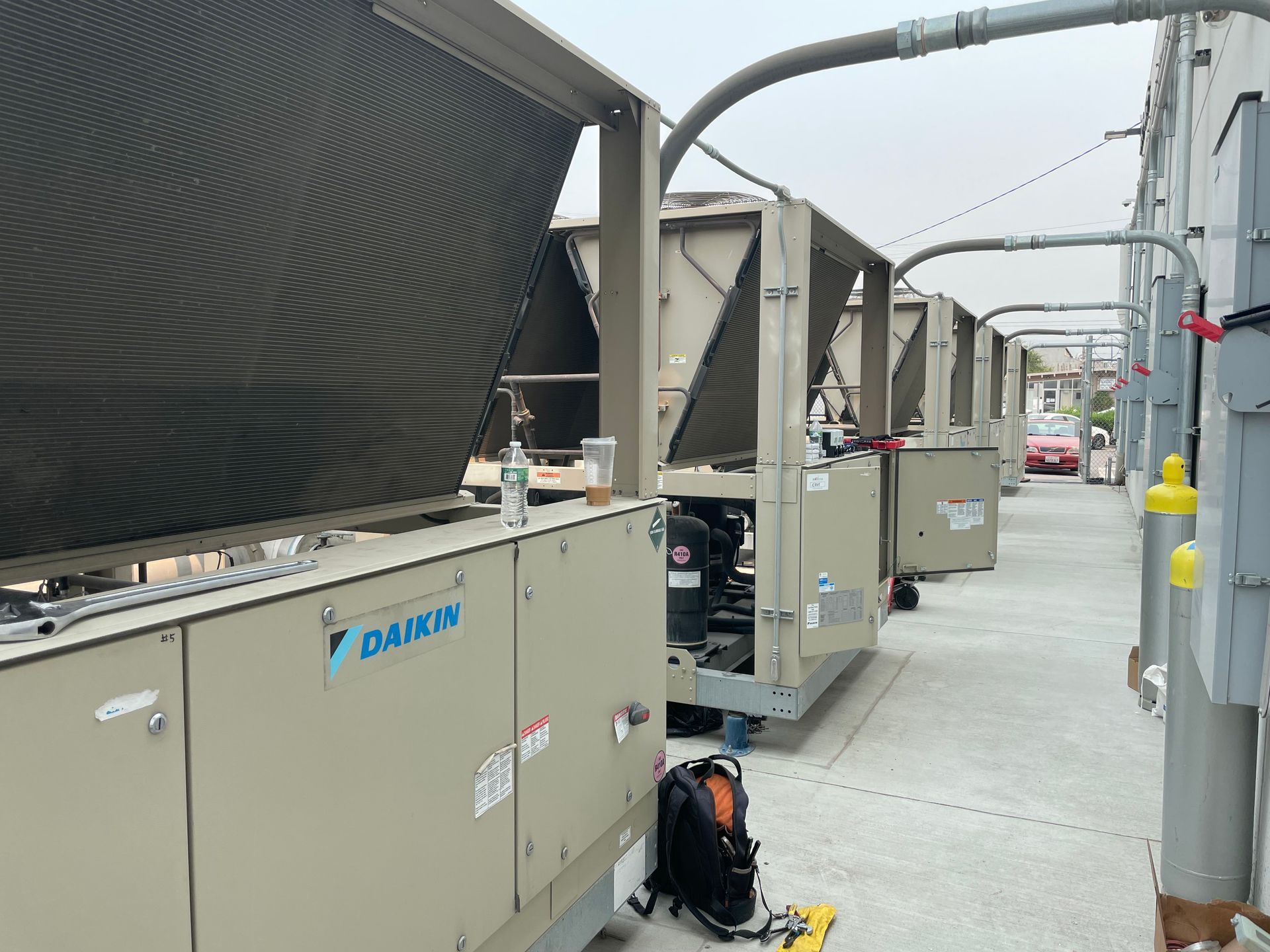 A row of daikin air conditioners are sitting on top of a concrete floor.